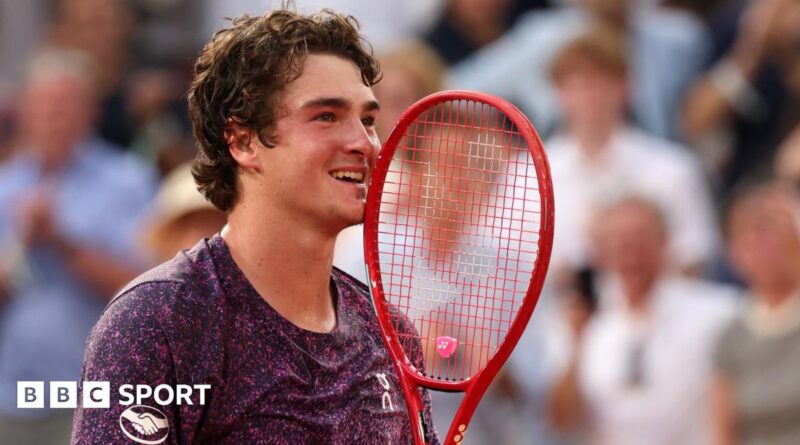 Joao Fonseca holds his racquet to his face in celebration