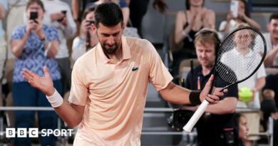 Novak Djokovic, wearing a peach polo shirt, dances with his racquet in his left hand