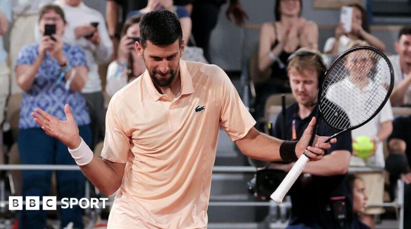 Novak Djokovic, wearing a peach polo shirt, dances with his racquet in his left hand