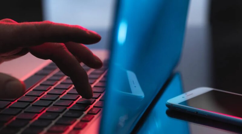 Man typing on a laptop.