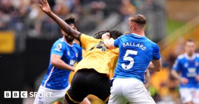 Referee Paul Tierney speaks with Lisandro Martinez of Manchester United after showing him a red card for pulling the hair of Dominic Calvert-Lewin of Leeds United