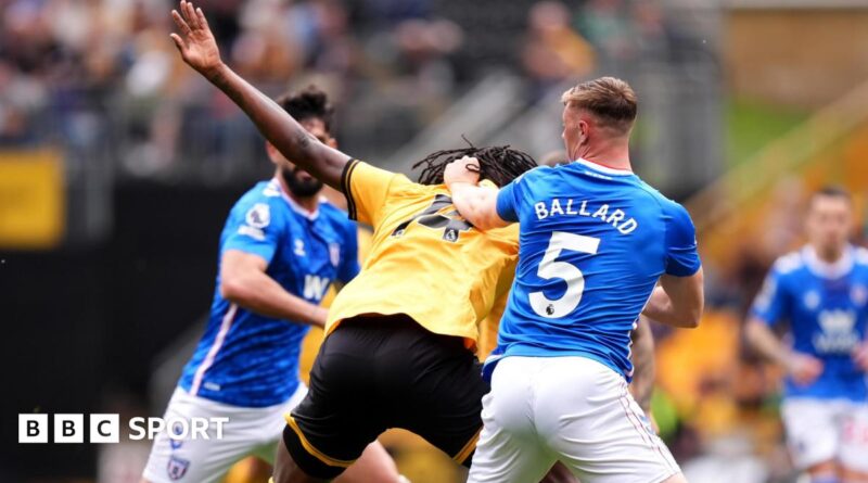 Referee Paul Tierney speaks with Lisandro Martinez of Manchester United after showing him a red card for pulling the hair of Dominic Calvert-Lewin of Leeds United
