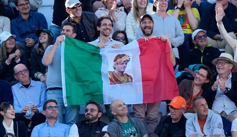 Fans of Jannik Sinner, of Italy, hold an Italian flag with his picture during his final match against Casper Ruud, of Norway, at the Italian Open tennis tournament, in Rome, Sunday, May 17, 2026. (AP Photo/Alessandra Tarantino)