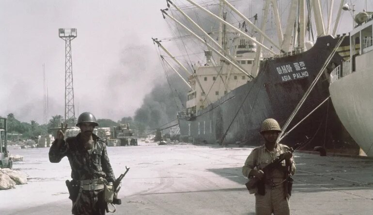 Iraqi forward troops stand guard over shipping at the dockside in occupied Khorramshahr, Iran on Oct. 7, 1980. (AP Photo)