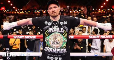 Oleksandr Usyk with his arms outstretched and 'Egypt 23.5.26' written on his right hand and 'winner' written on his left hand