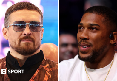 Oleksandr Usyk wearing sunglasses and and orange vest and Anthony Joshua wearing a white t-shirt