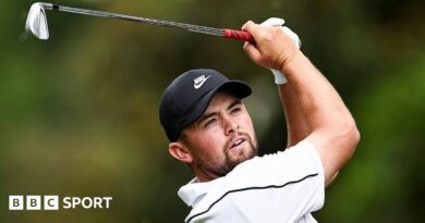 Alex Fitzpatrick watches his ball after playing an iron shot, with the club above his head