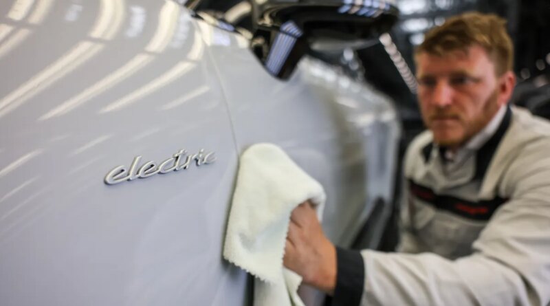 A Porsche employee checks an all-electric Porsche Macan in quality control at the Leipzig plant.