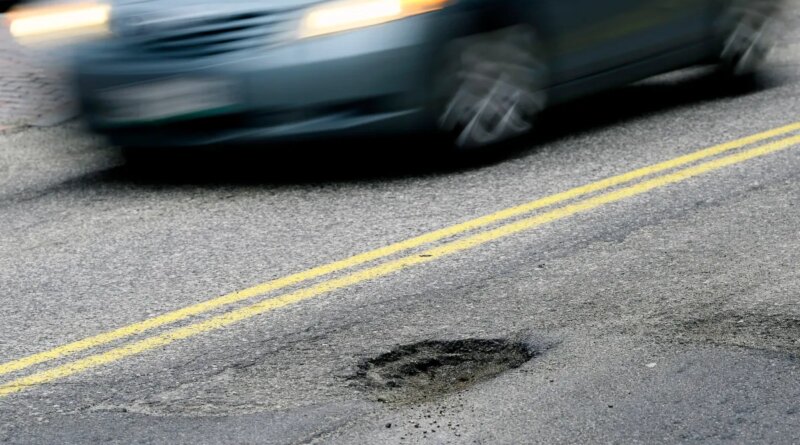 CAPE ELIZABETH, ME - FEBRUARY 22: A car drives past a pothole on Forest Ave. in Portland Tuesday, February 22, 2022. (Shawn Patrick Ouellette/Portland Press Herald via Getty Images)