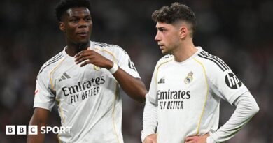 Real Madrid's Aurelien Tchouameni and Federico Valverde stand next to each other in a match, wearing the club's white kit