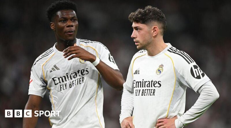 Real Madrid's Aurelien Tchouameni and Federico Valverde stand next to each other in a match, wearing the club's white kit