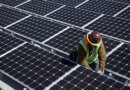 A man inspects solar panels.