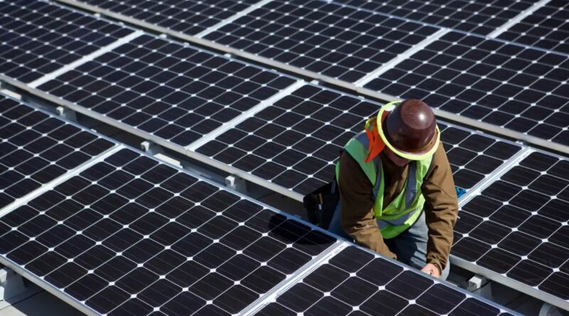 A man inspects solar panels.