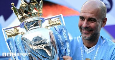 Manchester City manager Pep Guardiola holding the Premier League trophy