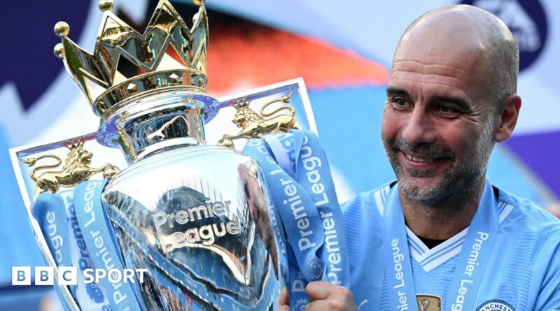 Manchester City manager Pep Guardiola holding the Premier League trophy