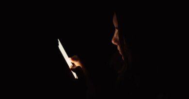 Lady looking at smartphone in dark room.