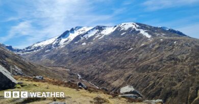 Photograph of a mountain with snow on the peaks along with sunny spells