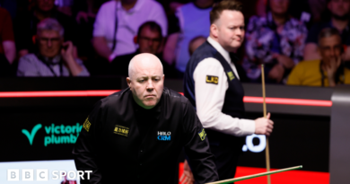 John Higgins eyes a shot