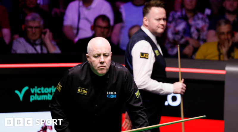 John Higgins eyes a shot