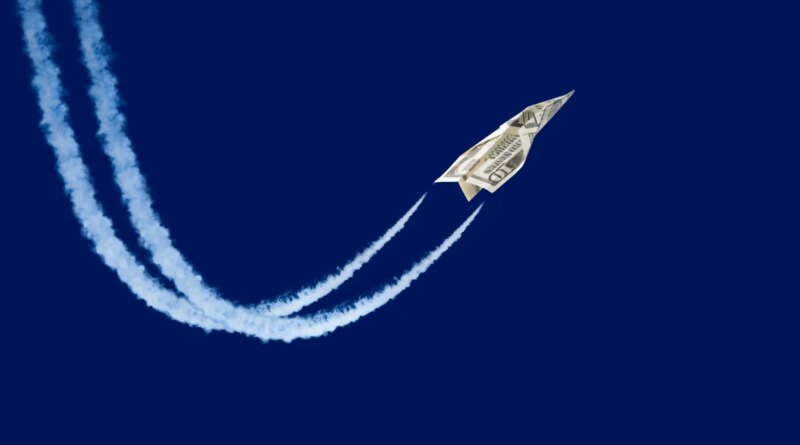 paper plane made from a ten-dollar bill 'flying' with contrails
