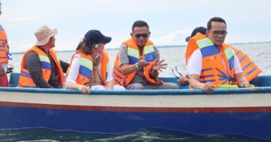 Indonesian diplomat Tri Tharyat sits in a boat with other officials wearing life jackets on the water.
