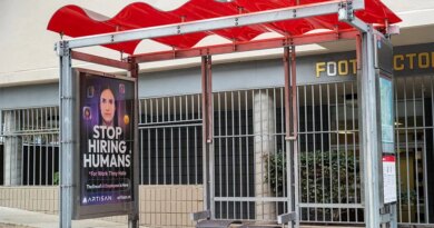 Bus stop shelter with red canopy and ad for Artisan AI reading "Stop Hiring Humans" and "For Work They Hate" on city sidewalk, San Francisco, California, September 30, 2025. (Photo by Smith Collection/Gado/Getty Images)