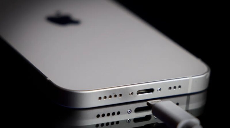 A Apple Lightning port charging cable is seen with with an iPhone.