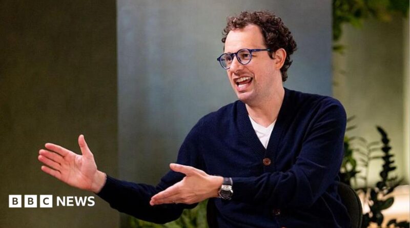 Dario Amodei, co-founder and chief executive officer of Anthropic, speaking during an interview in a room decorated with plants