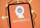 The Anthropic logo is displayed on the screen of a smartphone with the company's branding in the background.