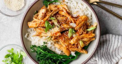 Crockpot honey garlic chicken served over white rice with broccolini in a bowl