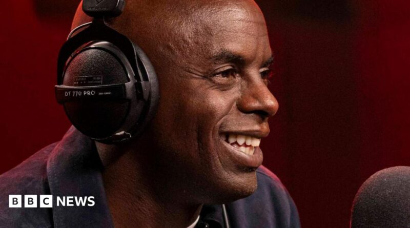 Trevor Nelson smiling while speaking into a radio mic