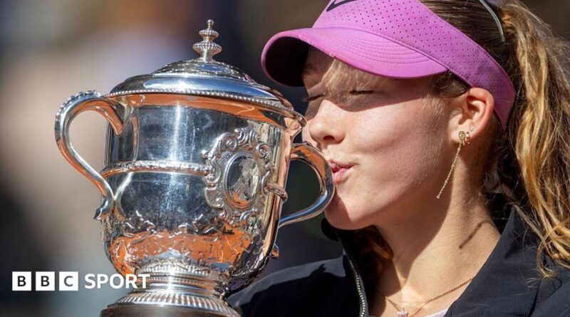 A close-up of Mirra Andreeva's jacket bearing the phrase 'I want to thank myself' while she holds the French Open winners' trophy