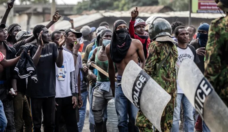 Demonstrators chant slogans as they confront Kenyan police officers during clashes at a demonstration against a controversial US-built Ebola quarantine centre slated to begin operations at Laikipia Air Base in Nanyuki on June 9, 2026. Several Kenyans were arrested on June 9, 2026 in the latest protests against an Ebola quarantine centre being built for US citizens in a tourist town.The centre at Laikipia Air Base in the town of Nanyuki, under the shadow of Mount Kenya, is set to quarantine Americans arriving from the Democratic Republic of Congo (DRC), which is battling a major Ebola outbreak. (Photo by Luis TATO / AFP)