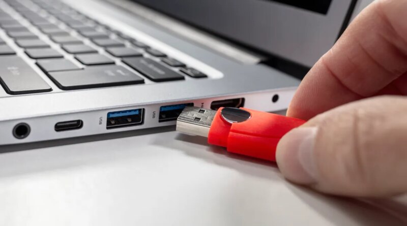 A USB flash drive stick and a laptop computer.