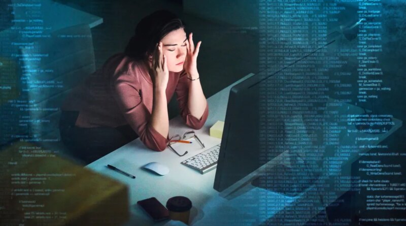 Shot of a young programmer working on computer code at night and looking stressed