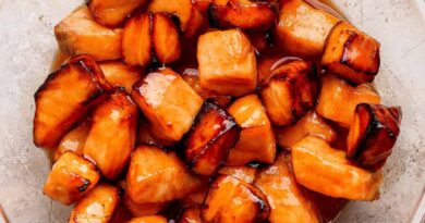 Cubes of cooked salmon in a glass bowl, coated with a shiny, dark caramelized glaze.
