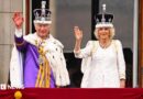 King Charles and Queen Camilla on the Buckingham Palace balcony wearing crowns and robes
