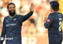 Yorkshire player Moeen Ali smiles and holds up his hand in celebration as he is approached by team-mate Dom Bess.
