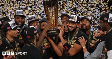 New York Knicks players holding the NBA Championship trophy