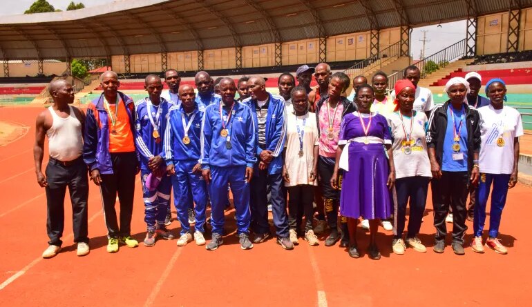Masters athletes in Meru stretch together before a morning session, turning a dusty village field into an informal training ground for seniors.