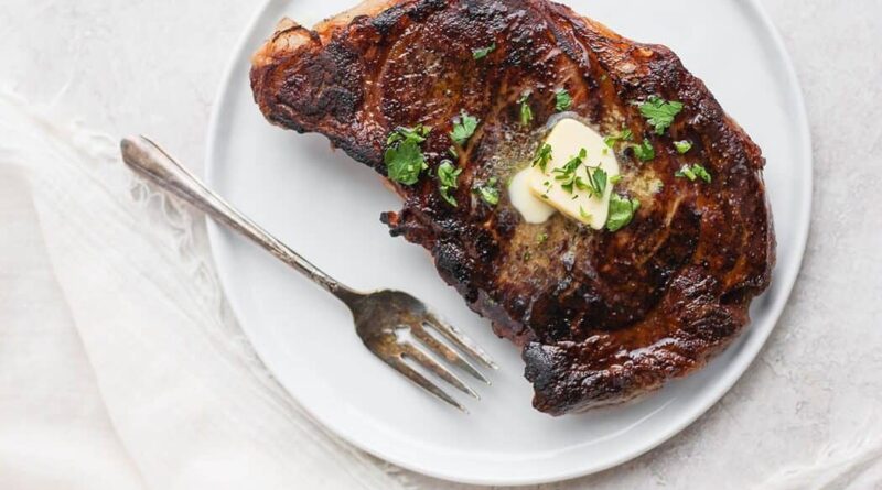 Sous vide steak with butter and fresh parsley on top.