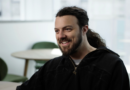 A caucasian man with long dark hair and a full beard