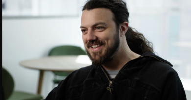 A caucasian man with long dark hair and a full beard
