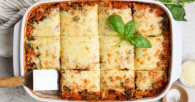 Overhead view of spinach quinoa lasagna casserole cut into squares in a baking dish