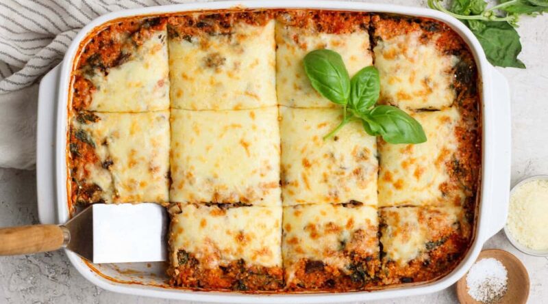 Overhead view of spinach quinoa lasagna casserole cut into squares in a baking dish