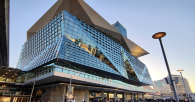 Sydney modern skyline viewed at Darling Harbor. People walking on the pedestrian zone in central Sydney.