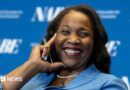 Lisa D. Cook, a member of the Board of Governors of the Federal Reserve, smiles while holding her hand against her face. She is wearing a blue suit and speaks at The Capital Hilton during the 42nd annual National Association for Business Economics Economic Policy Conference on February 24, 2026 in Washington, DC.