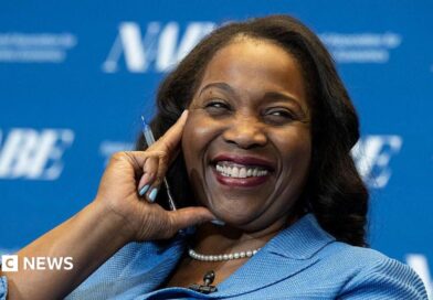 Lisa D. Cook, a member of the Board of Governors of the Federal Reserve, smiles while holding her hand against her face. She is wearing a blue suit and speaks at The Capital Hilton during the 42nd annual National Association for Business Economics Economic Policy Conference on February 24, 2026 in Washington, DC.