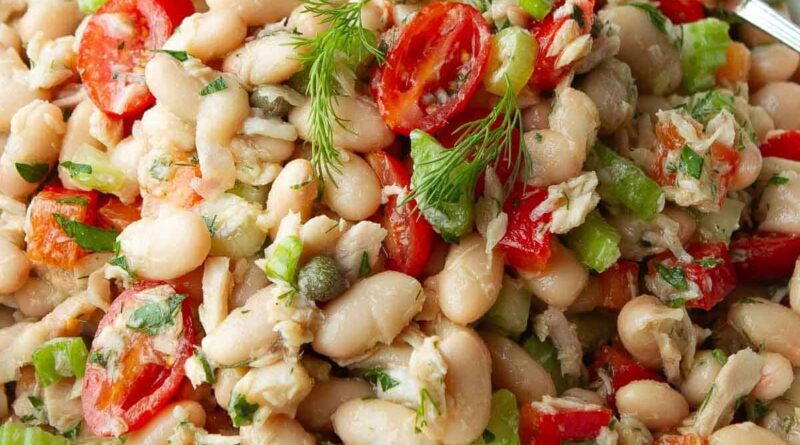Tuna white bean salad with tomatoes in a white bowl.