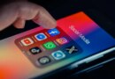 finger pointing to Facebook mobile app displayed on a smartphone screen
